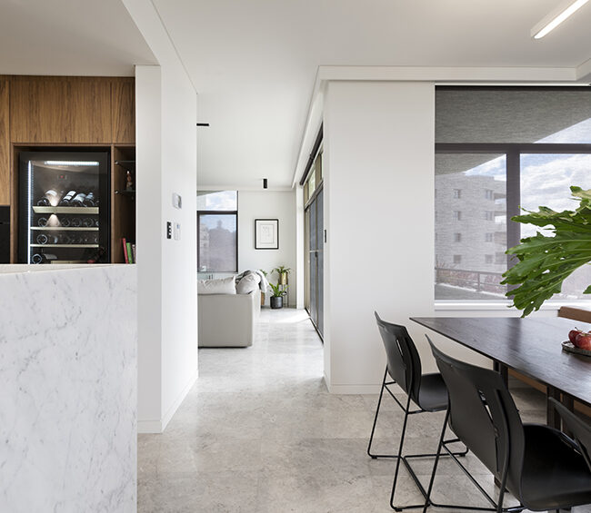 A modern kitchen and dining area highlighted by a large window, providing ample natural light and a welcoming atmosphere.