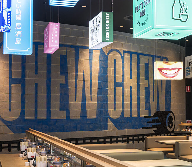 A restaurant facade with a large, eye-catching sign that reads "Chewy" prominently displayed.