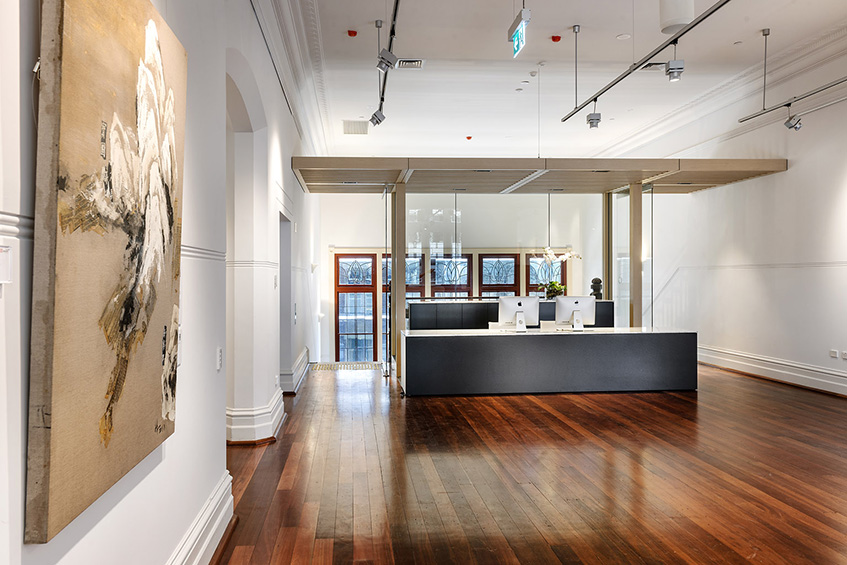 A spacious hallway adorned with a painting, showcasing a blend of colors and textures.